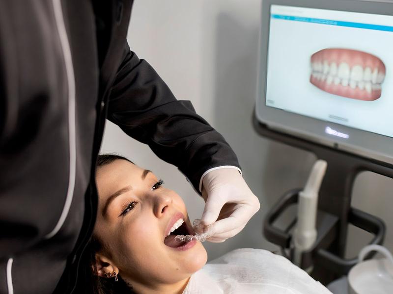 Dentist performing a checkup on a woman with a digital scan on the monitor