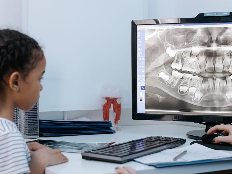 Child looking at a dental x-ray on a computer screen