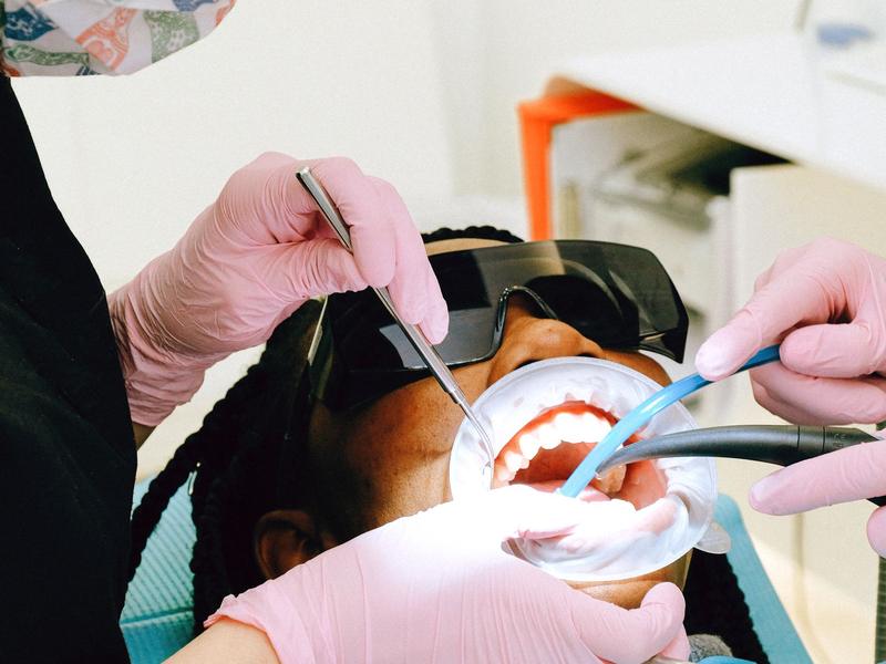 Hygienist cleaning a patient's teeth with dental instruments