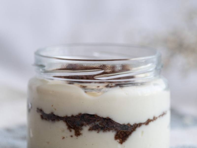 Glass jar of layered chocolate and cream dessert