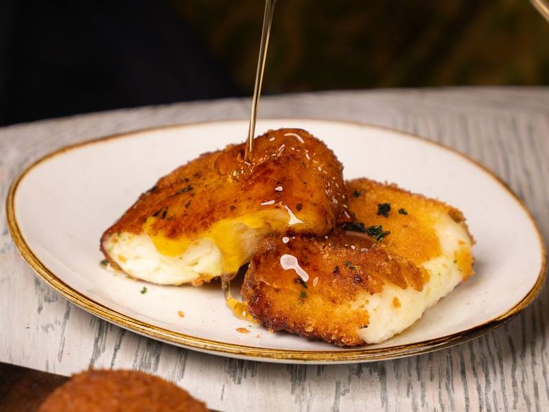 Pan-seared golden halloumi with a honey drizzle on a ceramic plate