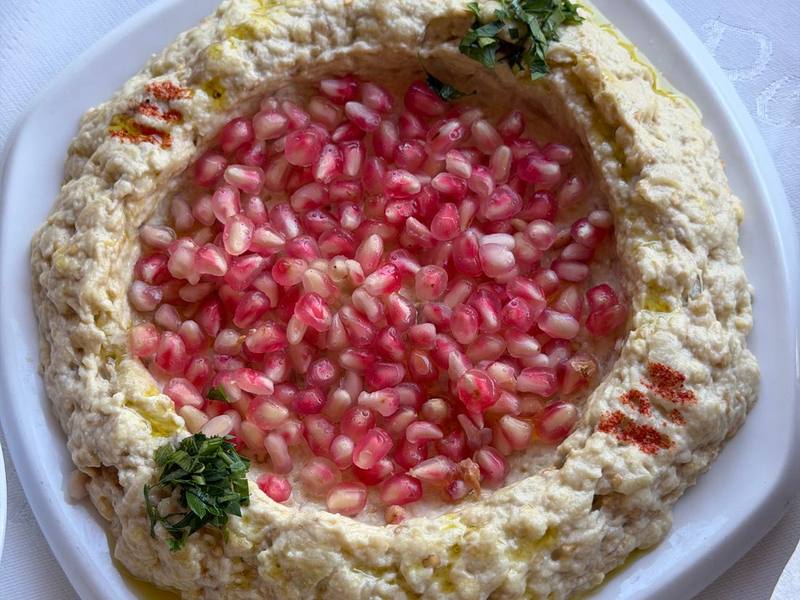 Baba ganoush eggplant dip topped with pomegranate seeds and herbs