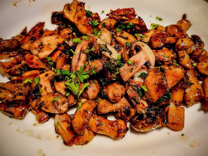 Mushrooms roasted with thyme, served on a white plate