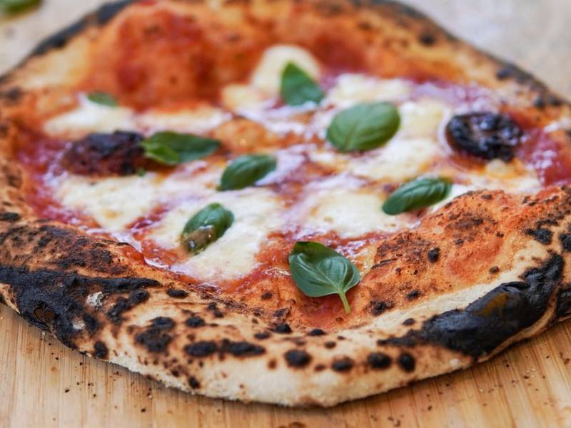 Wood-fired Margherita pizza with melted mozzarella and fresh basil